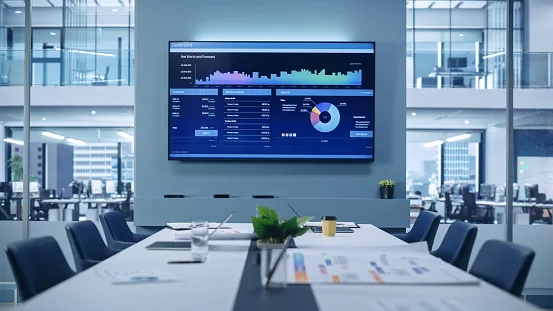 Conference room with a wall screen displaying a data analytics dashboard