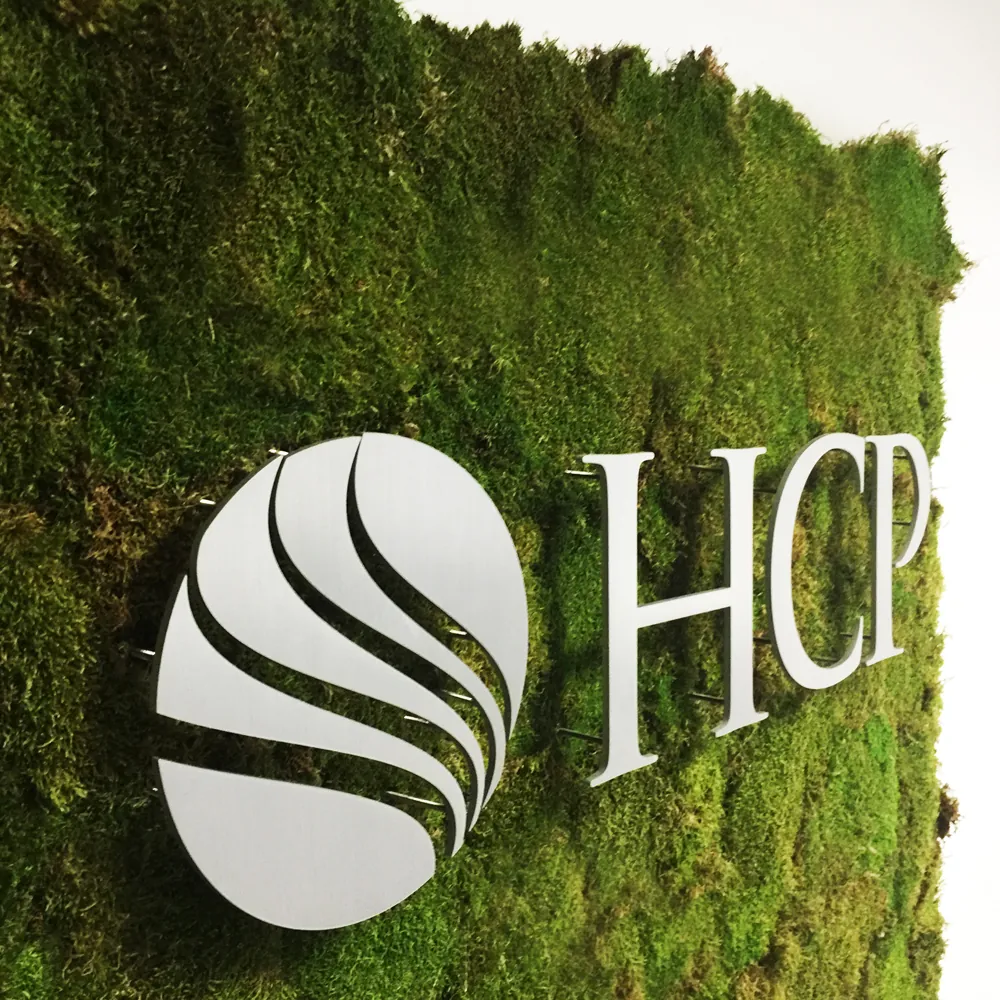 HCP Associates logo mounted on a living moss wall