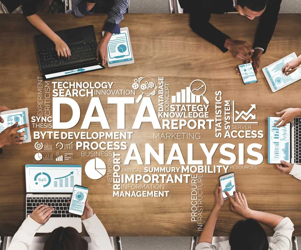 'Data Analysis' word cloud over a photo of people collaborating with laptops