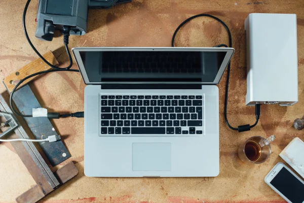 Top-down view of a laptop and camera equipment on a workbench