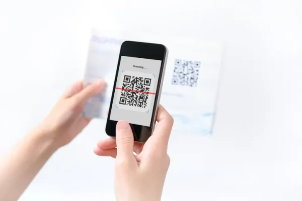 Hand holding a smartphone displaying a QR code