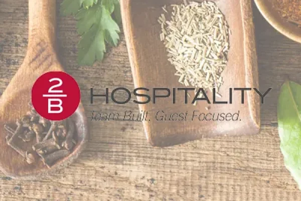 2B Hospitality logo over a background of spices and herbs