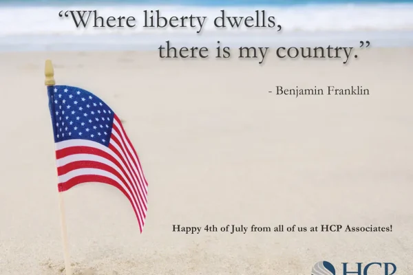 American flag on the beach with a Benjamin Franklin quote, wishing a Happy 4th of July from HCP Associates