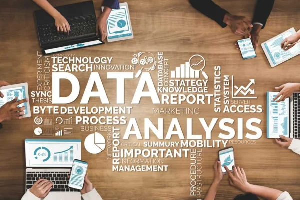 'Data Analysis' word cloud over a photo of people collaborating with laptops